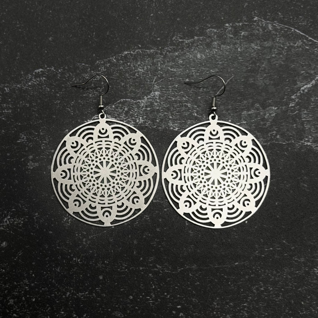 Stainless steel floral mandala earrings with intricate designs on a textured black background