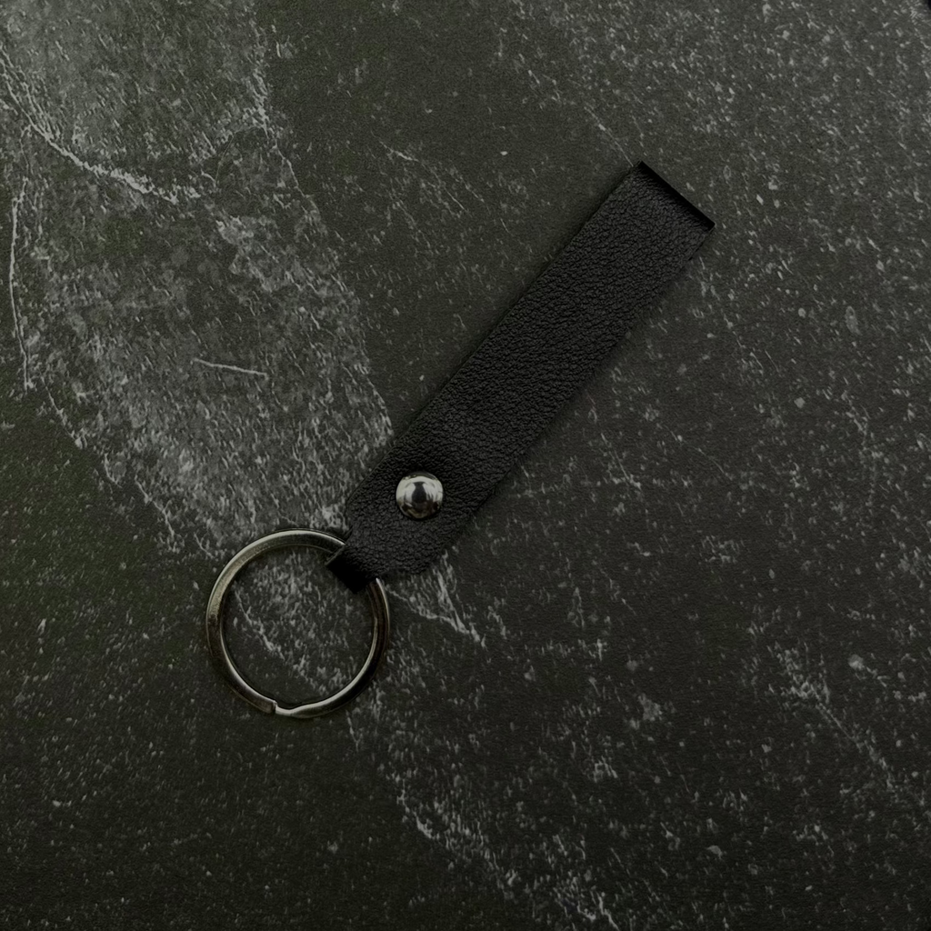 Black keychain on a black stone background. 