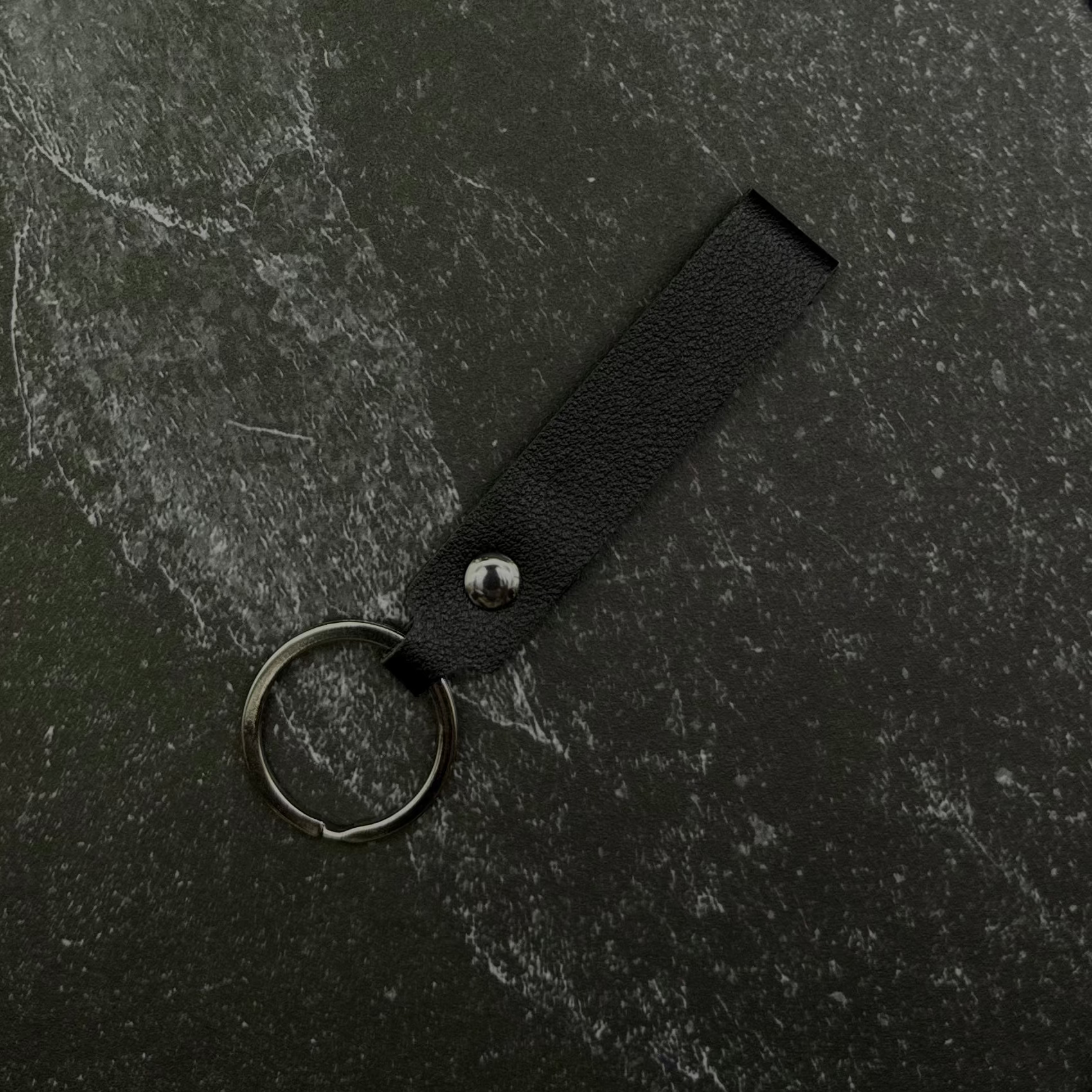 Black keychain on a black stone background. 