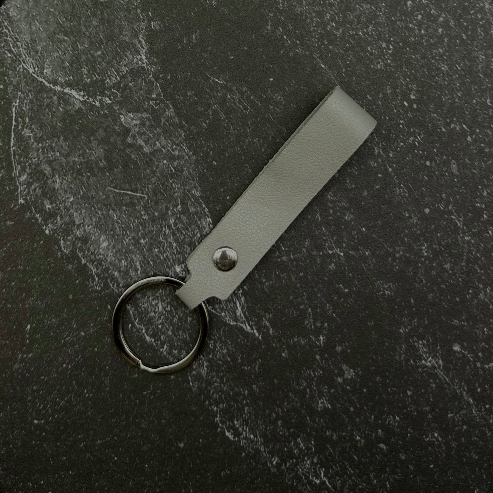 Gray keychain on a black stone background