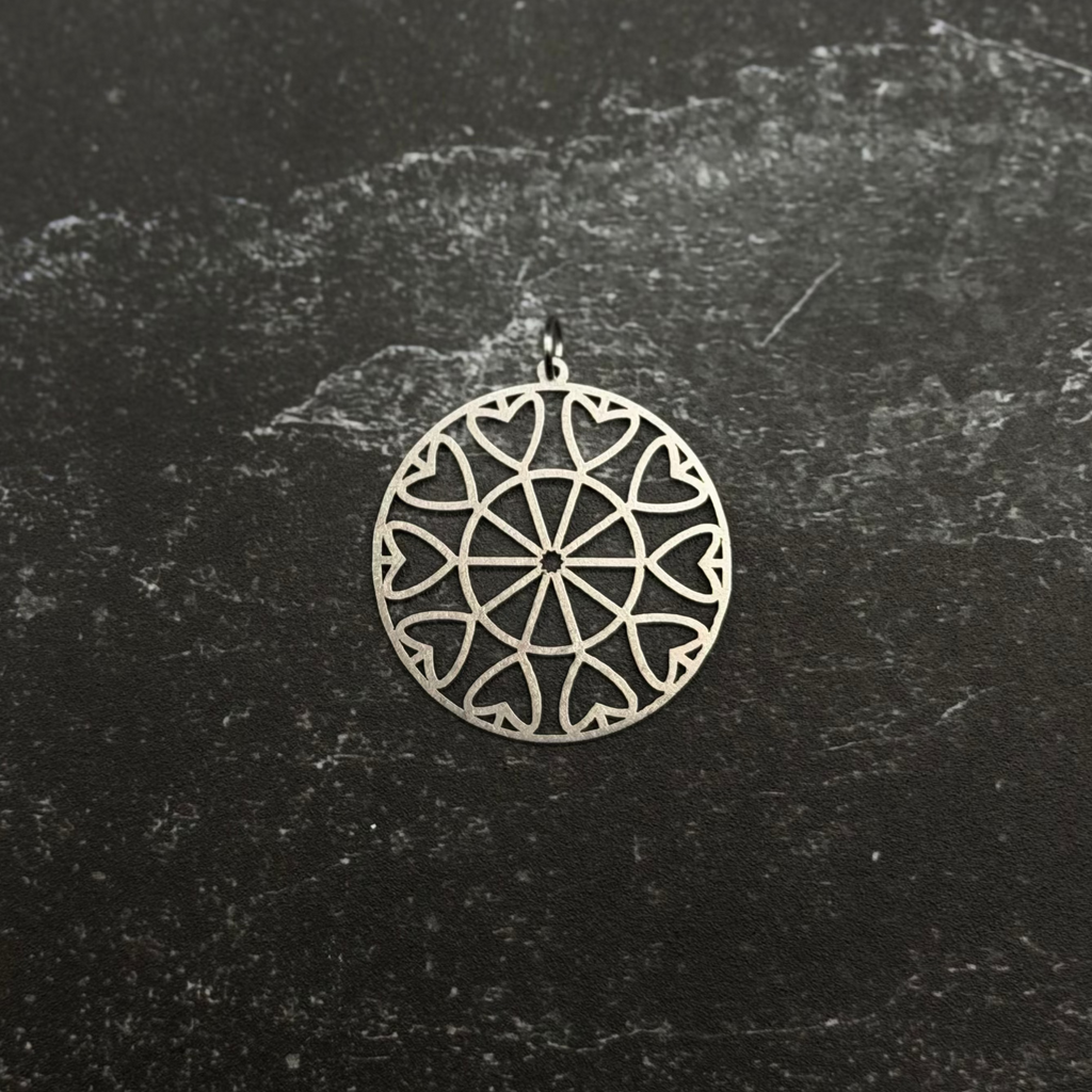Stainless steel heart geometric pendant on a black textured background