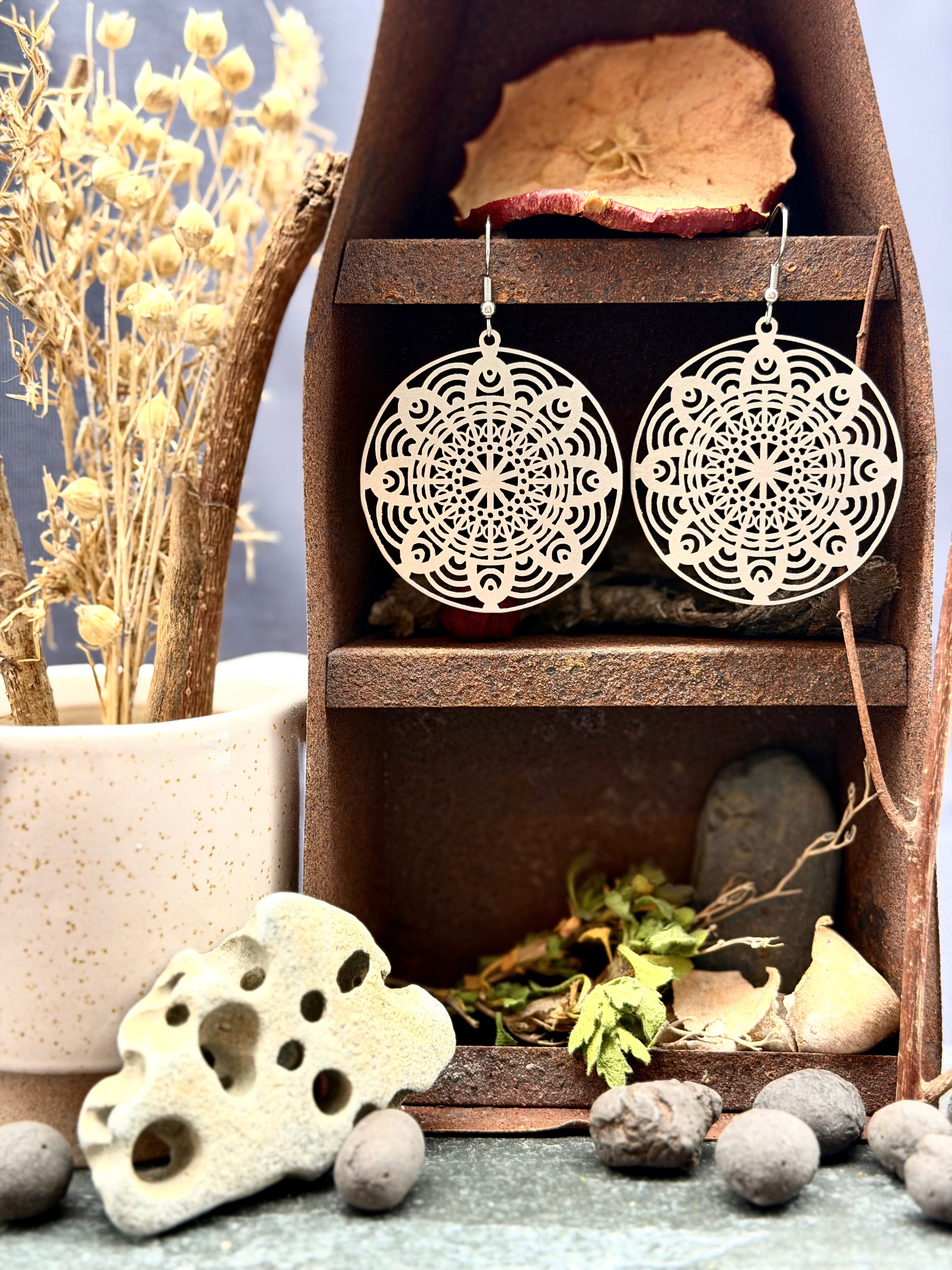 Decorative earrings on a wooden stand with natural elements around