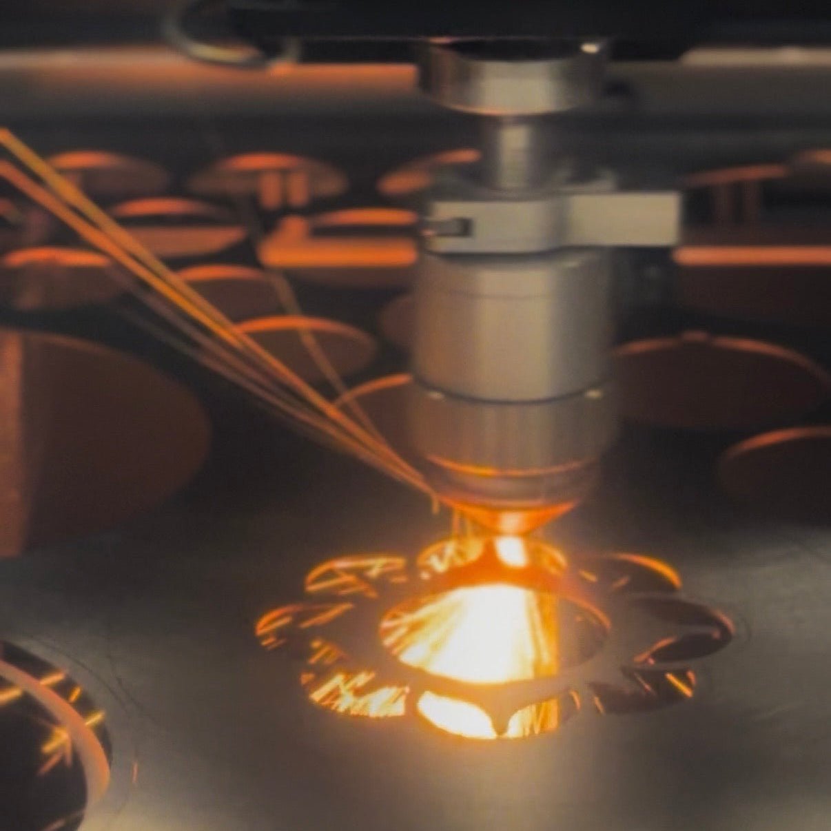 Close-up of a laser cutting machine in action cutting a flower with sparks flying.