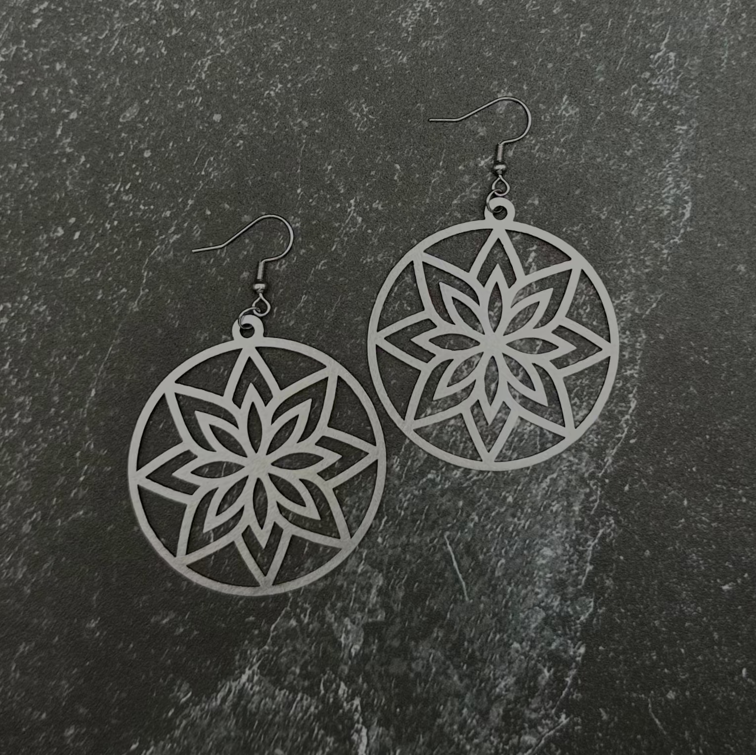 Star-shaped earrings on a dark stone surface