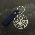 Stainless steel Keychain with lotus flower design on a dark surface
