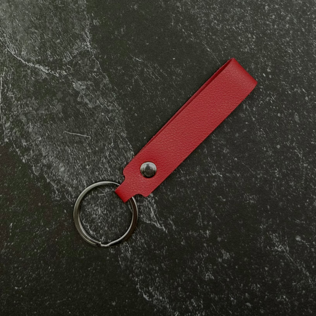 red leather keychain on a black stone background