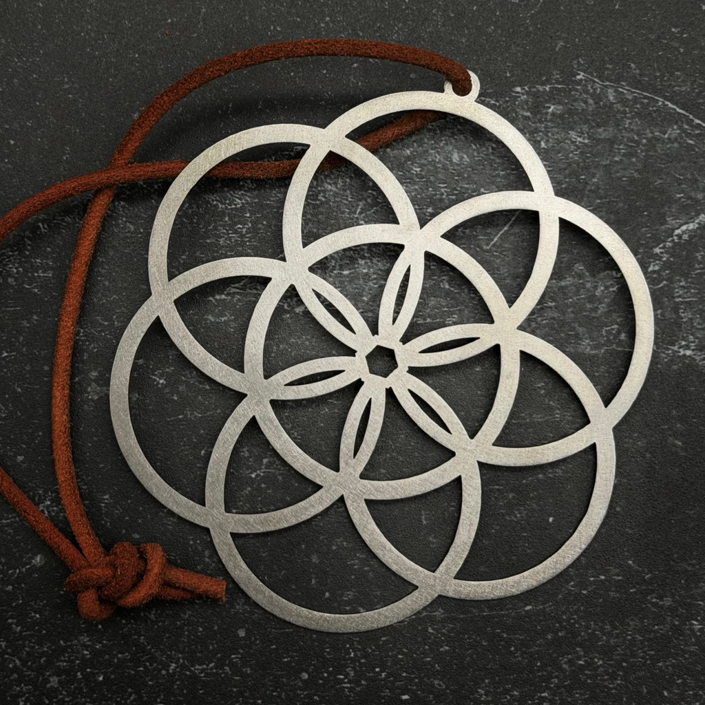 Stainless steel Decorative metal pendant with interlocking circles on a dark surface
