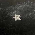 Stainless steel start pendant on a textured black surface