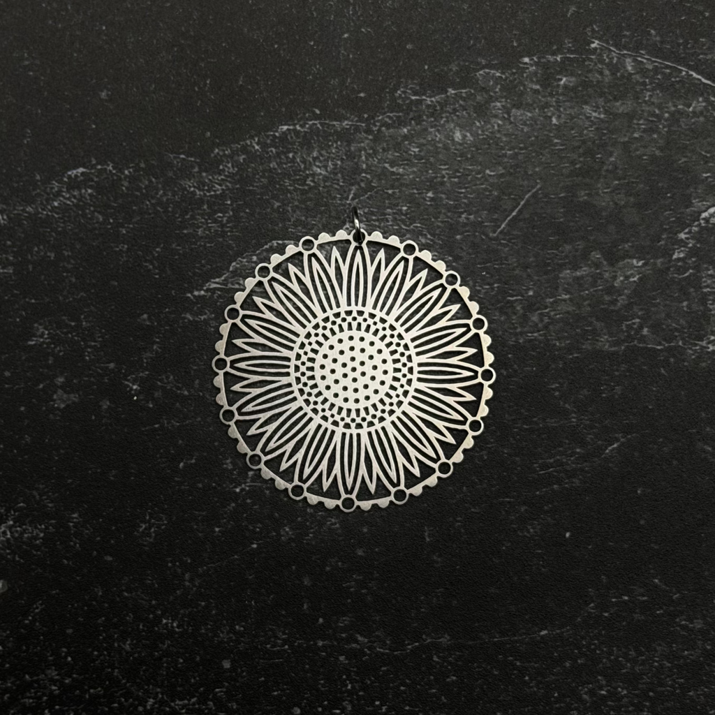 Stainless steel sunflower pendant on a black textured background