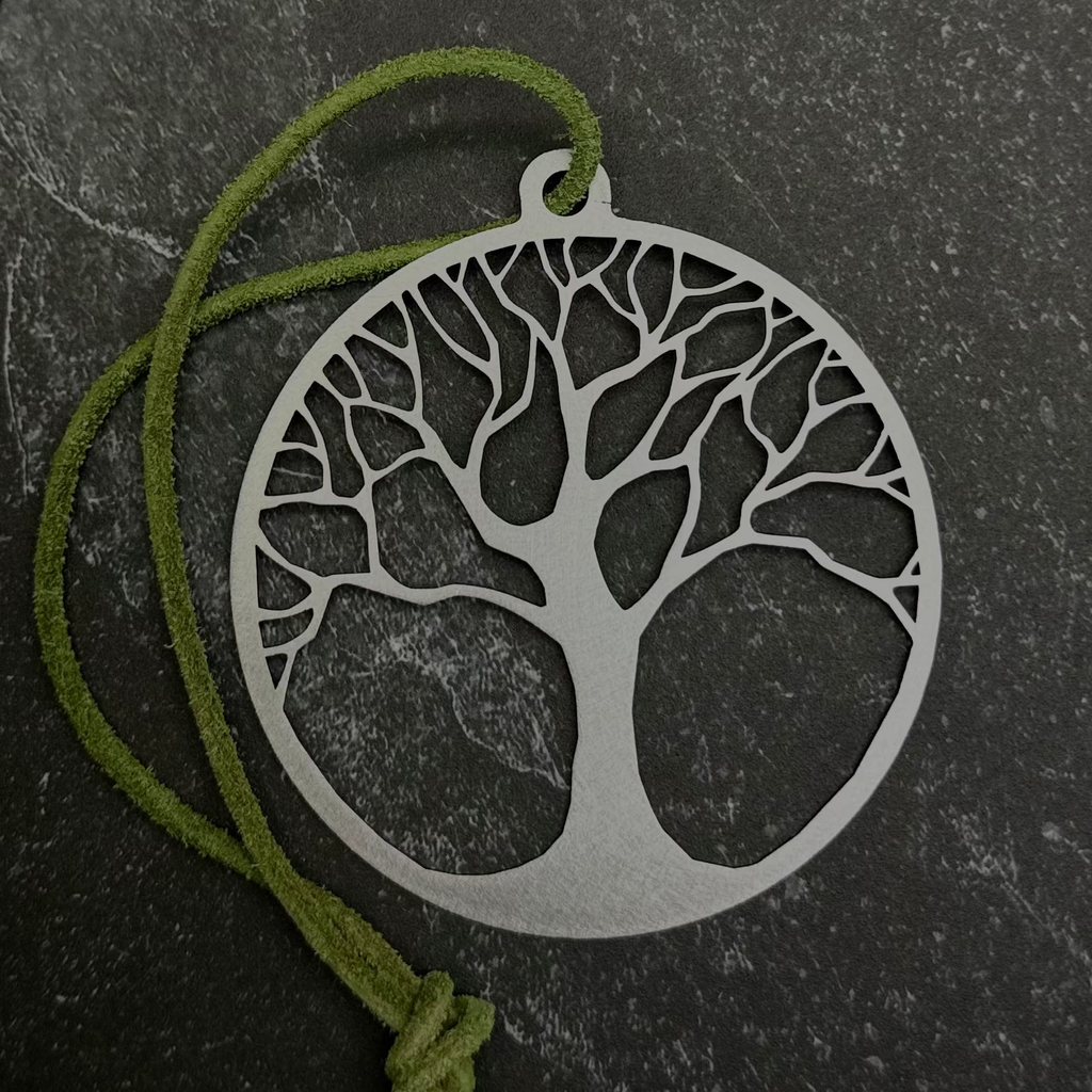 Tree of life ornament and green cord on a black background