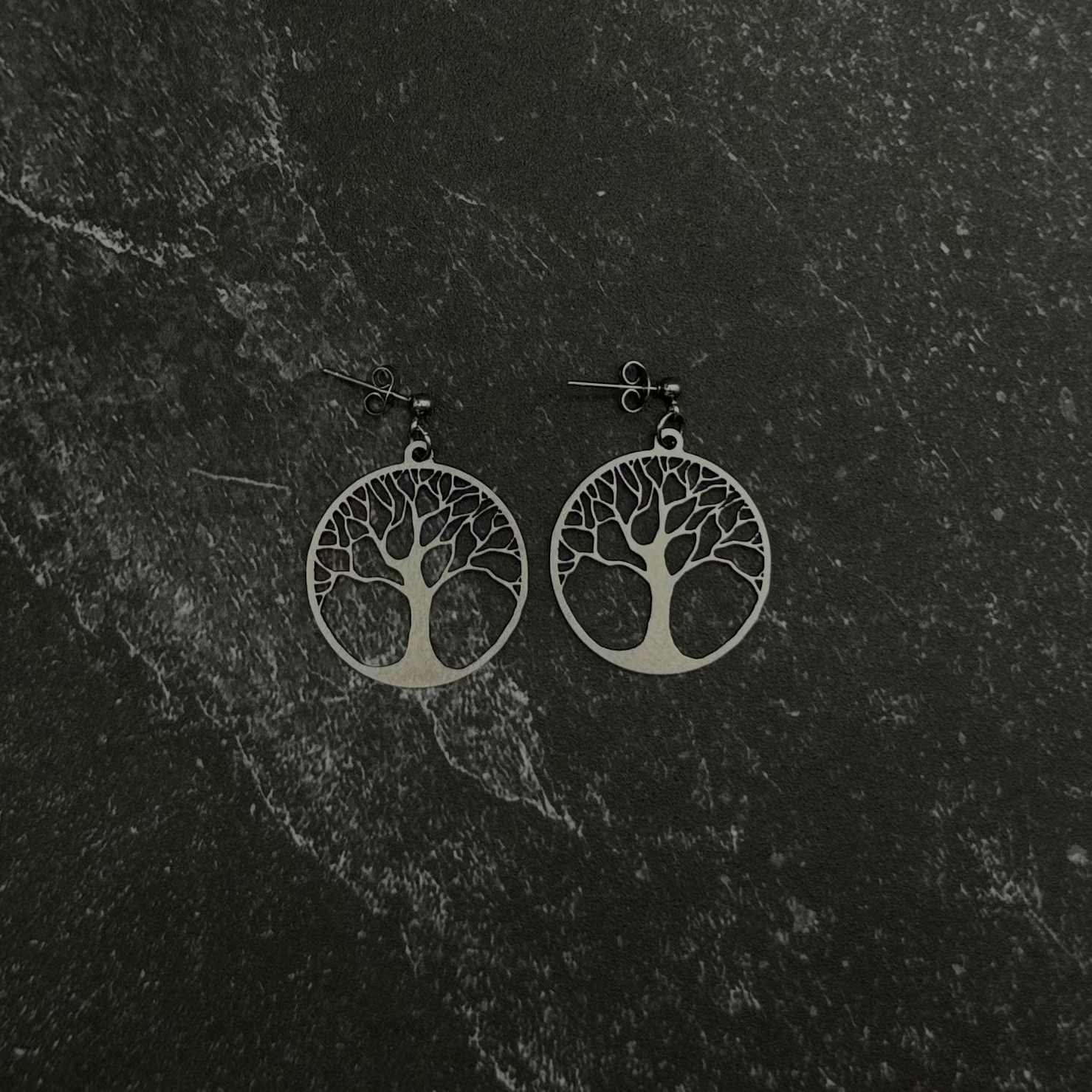 Tree of life earrings on black stone. 