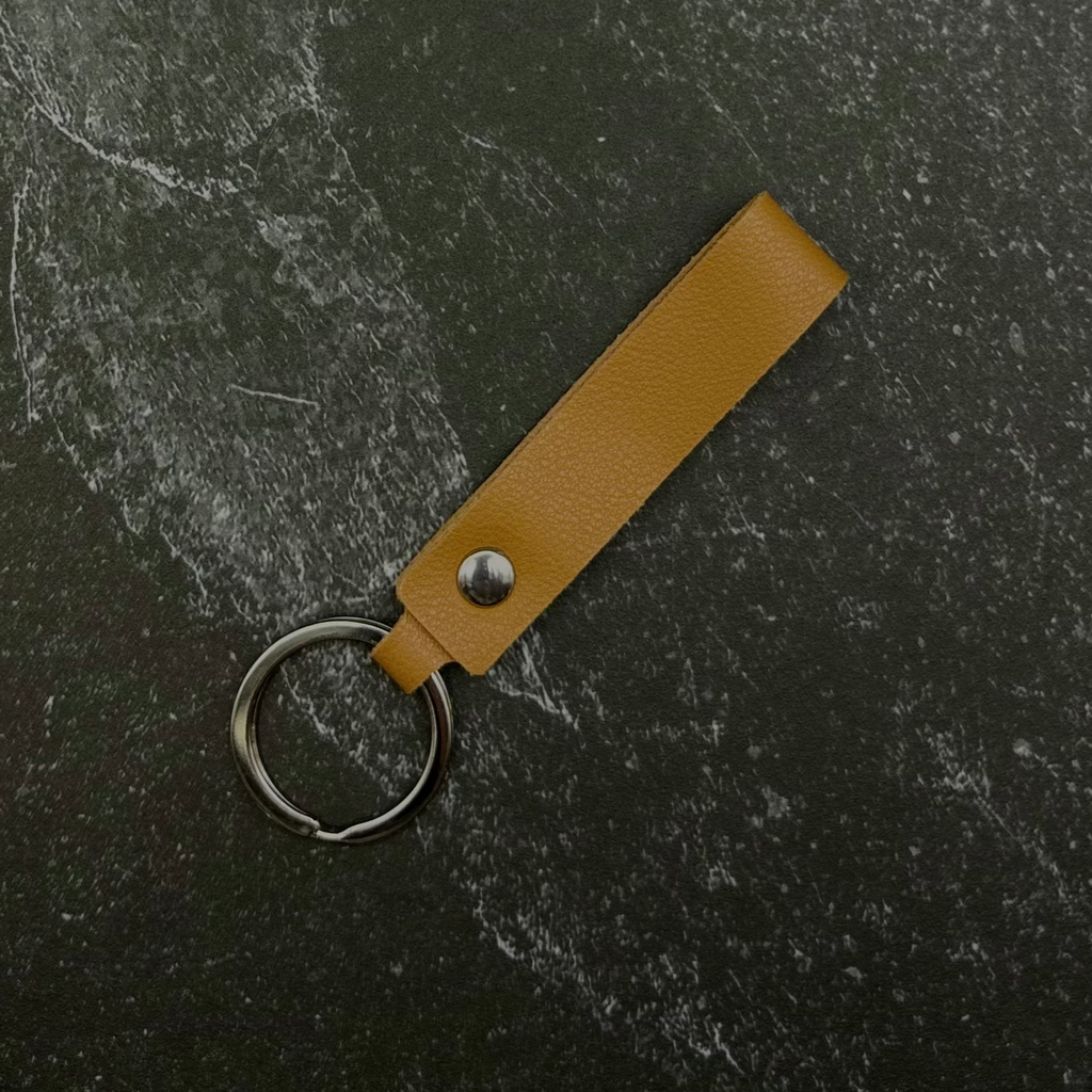 yellow leather keychain on a black surface