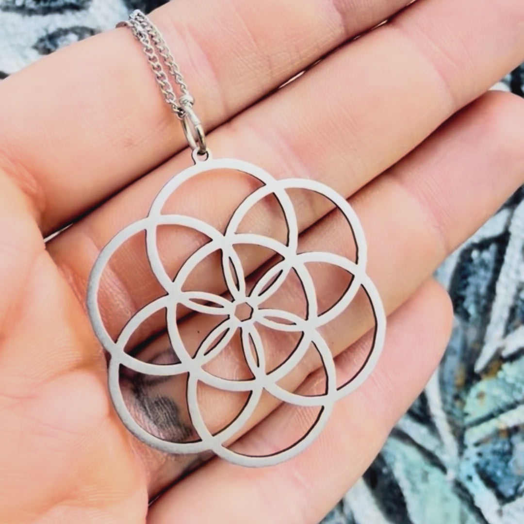 Stainless steel seed of life pendant with textured background. 