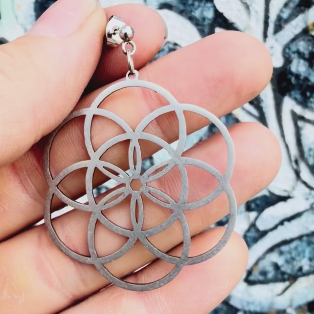 Stainless steel seed of life earring with textured background. 