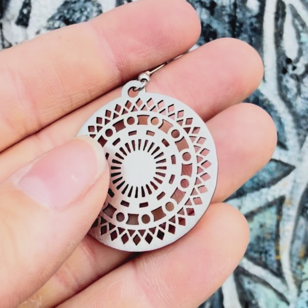 Stainless steel mosaic mandala earring with textured background. 