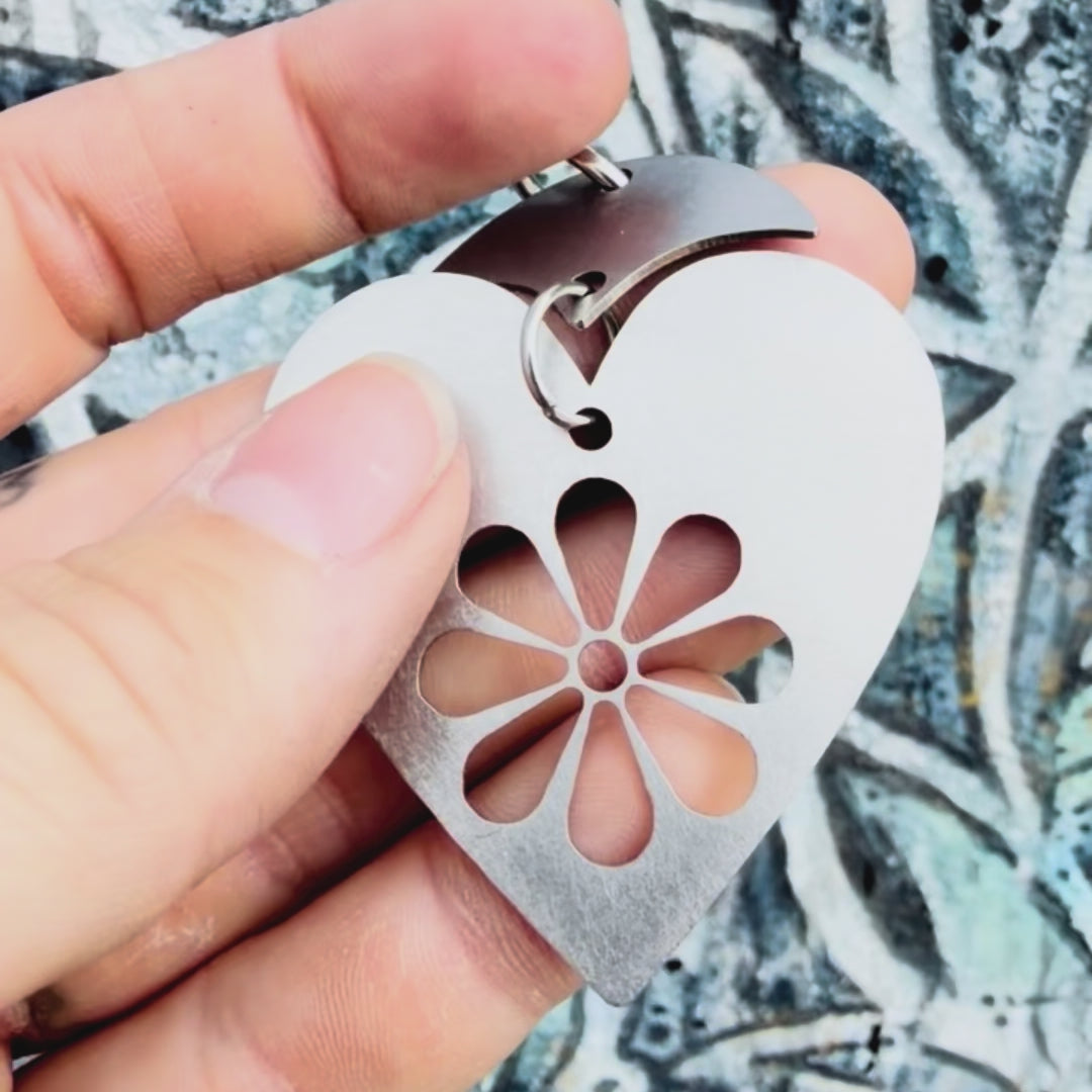 Stainless steel blooming heart pendant with textured background. 