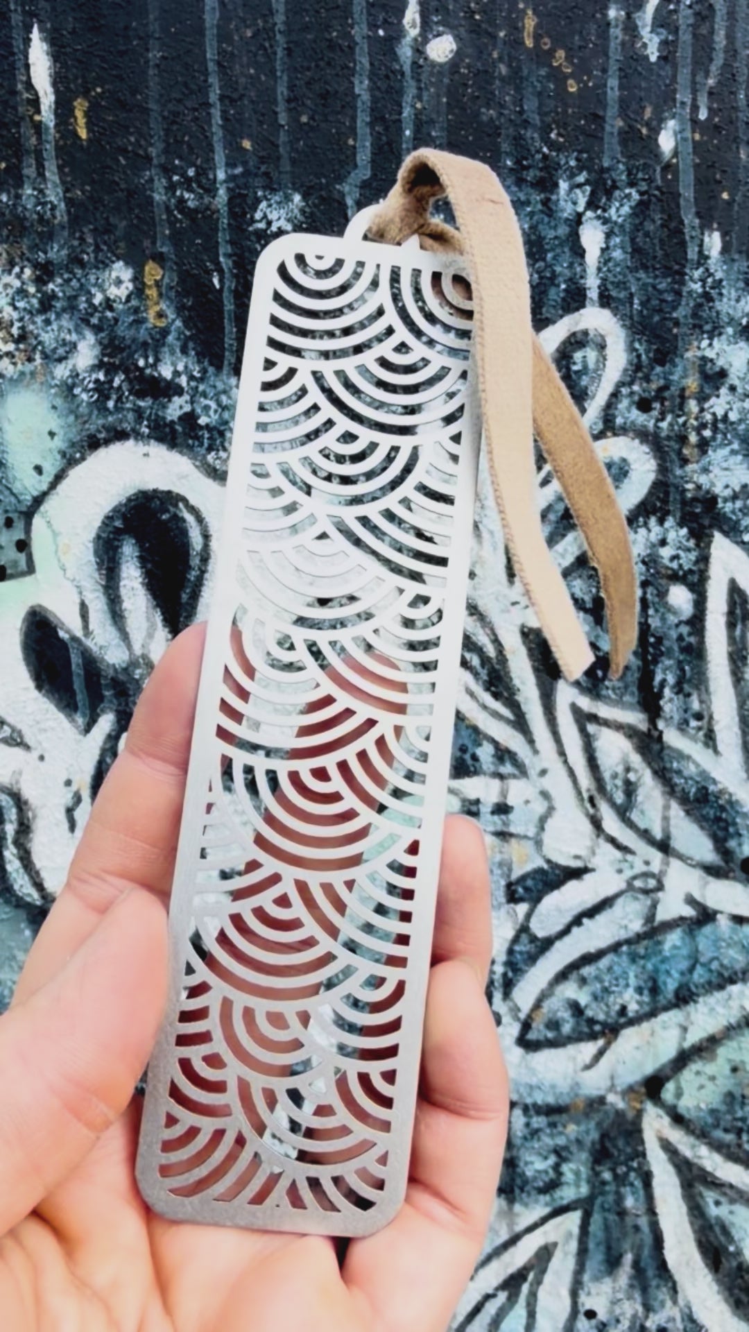 Stainless steel wave bookmark with textured background. 