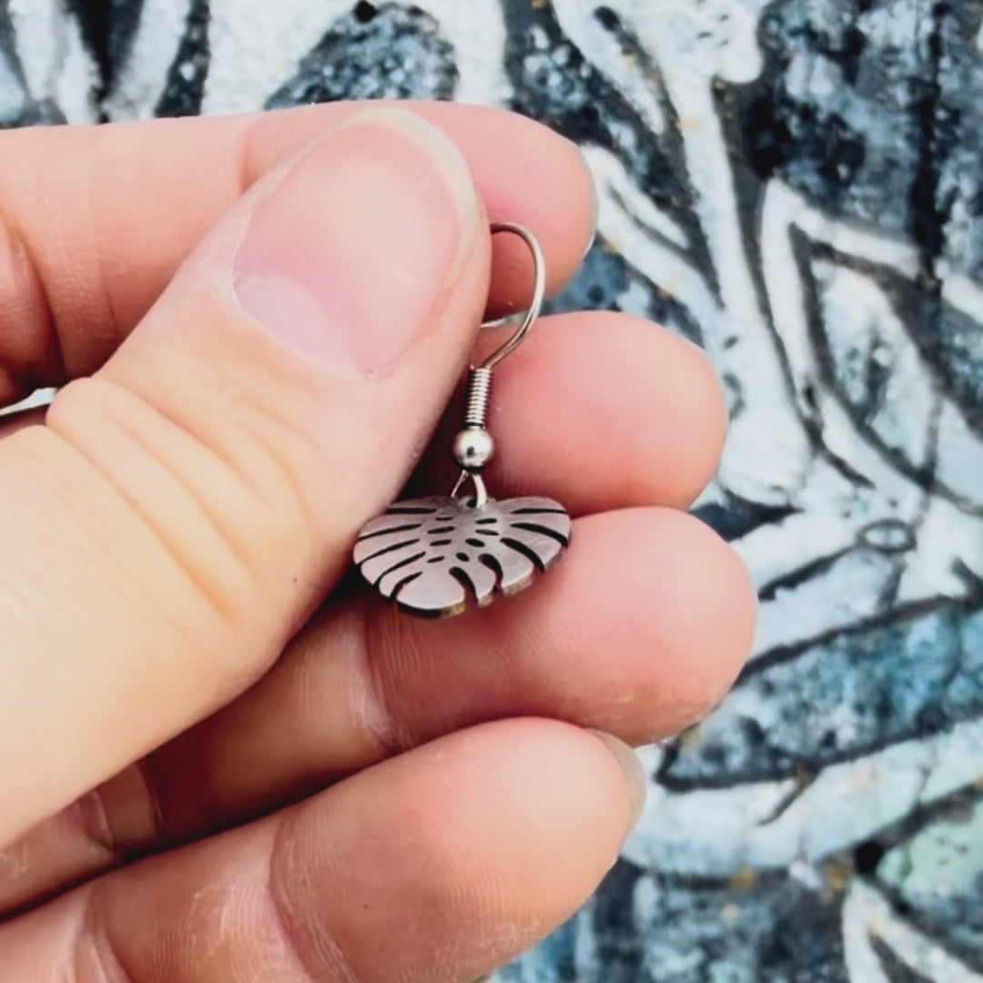 Stainless steel small monstera earring with textured background. 