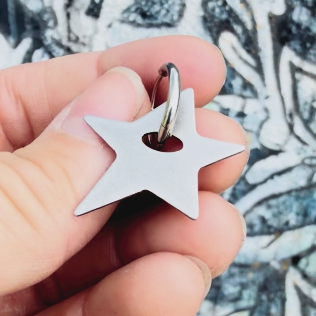 Stainless steel star earring with textured background. 