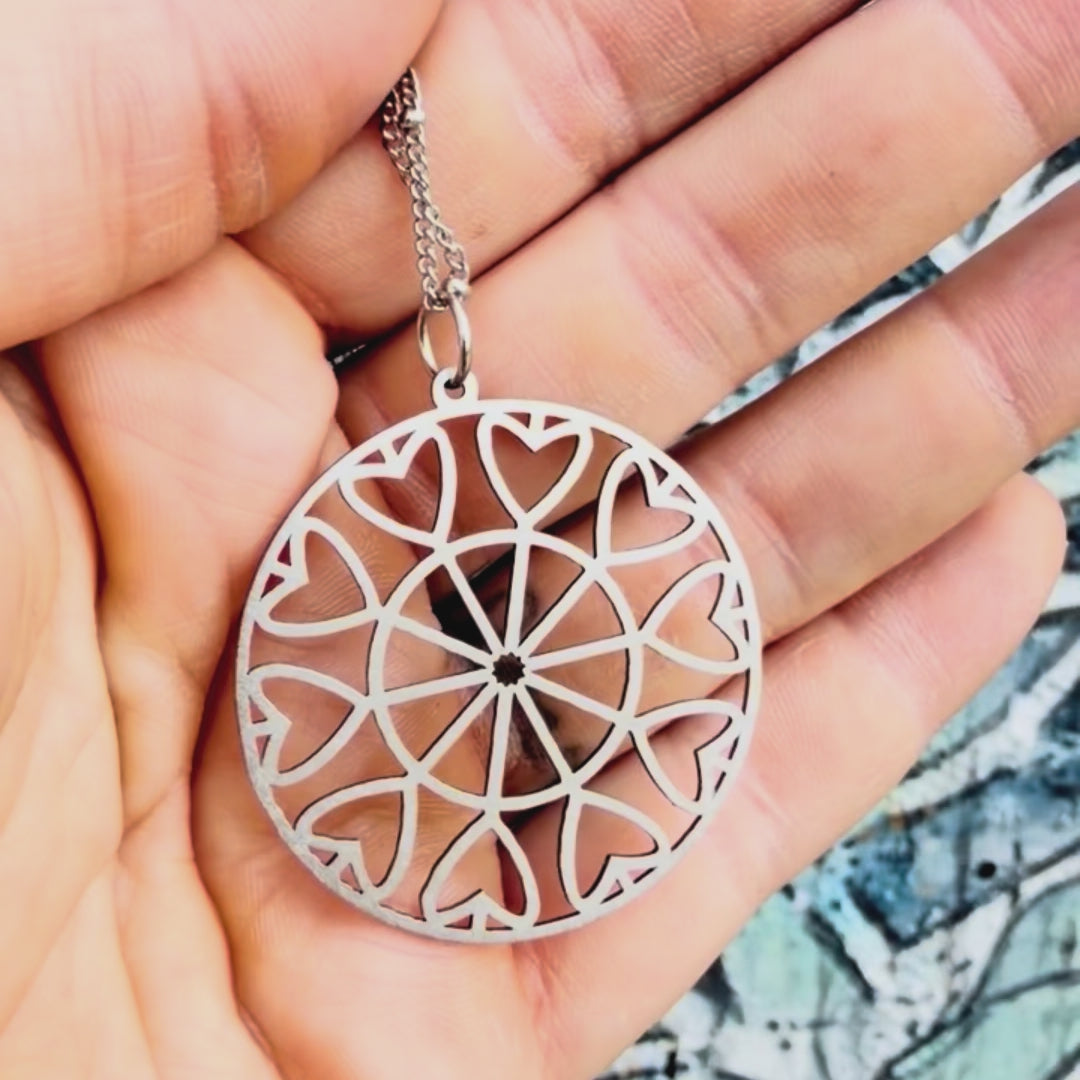 Stainless steel heart geometric pendant with textured background. 