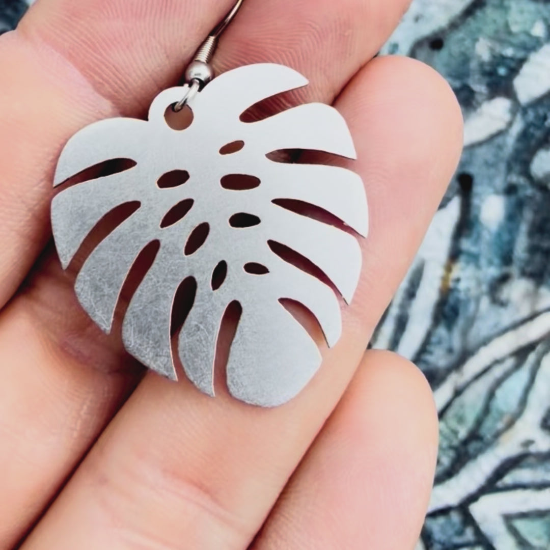 Stainless steel large monstera earring with textured background. 