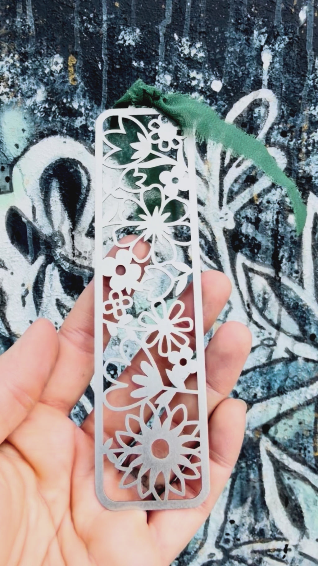 Stainless steel flower bookmark with textured background. 