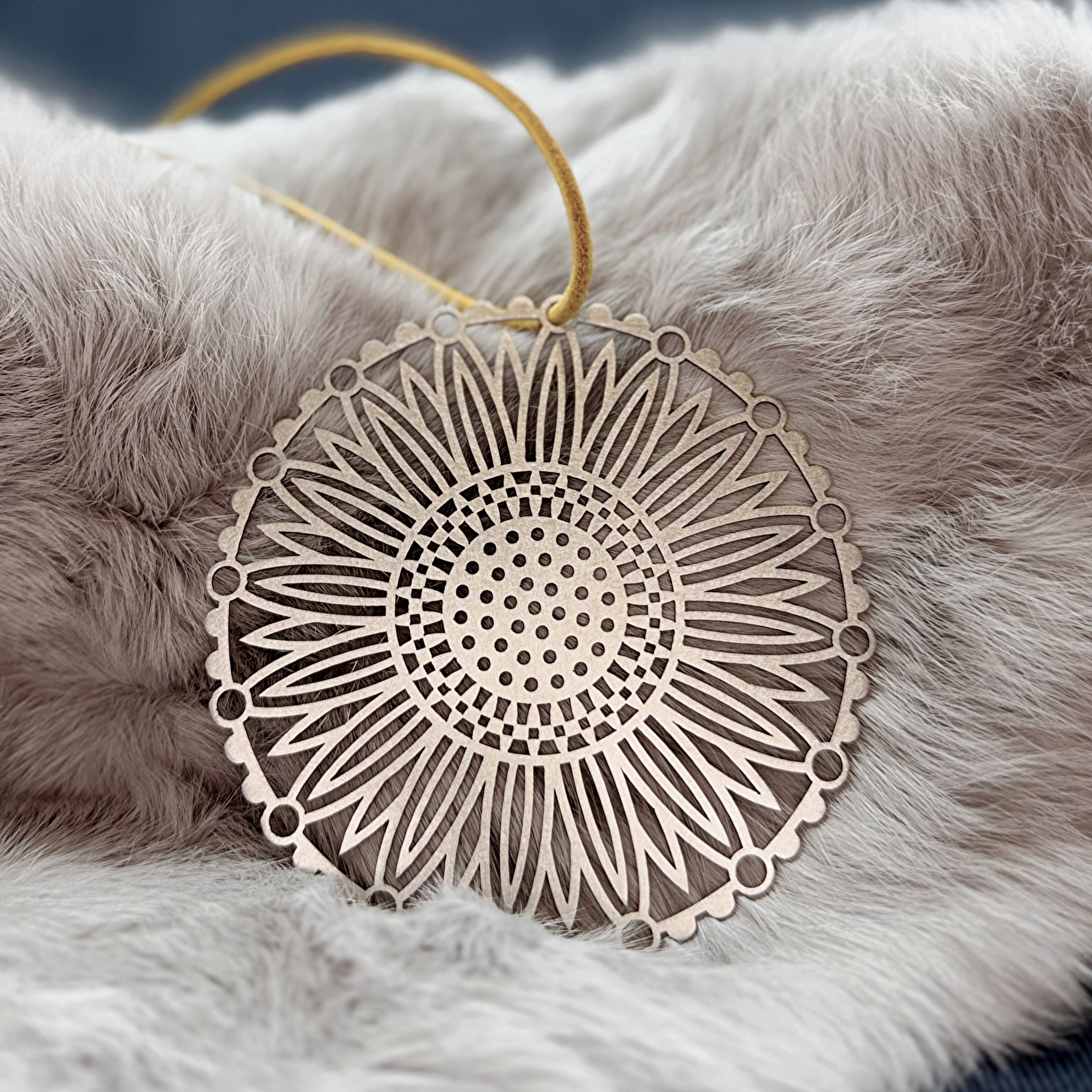 Decorative sunflower ornament with intricate patterns on a fluffy white surface